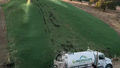 Professional hydroseeding on steep hillside for erosion control in Sacramento, CA landscaping project